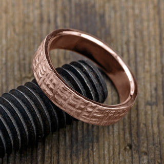 6mm men's wedding band made from 14k rose gold, displaying a textured matte design