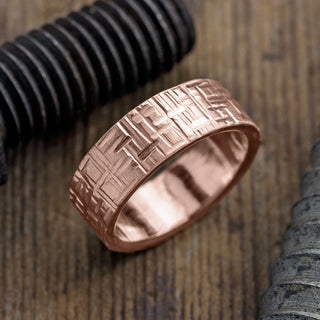 Close-up view of 8mm 14K Rose Gold Textured Men's Wedding Band with a Matte Finish