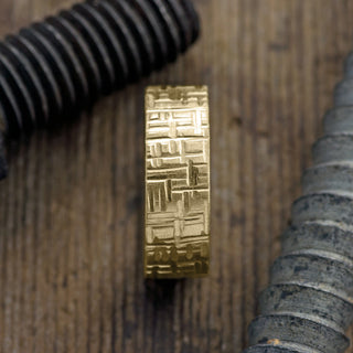 Detailed view of the texture on 8mm 14k yellow gold men's wedding band