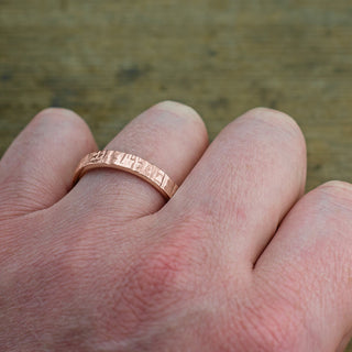 Stylish Male Wedding Band, 4mm in 14k Rose Gold with Textured Polished surface, showcased on a white background
