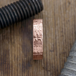 Close up of the textured polished design on the 14k rose gold men's wedding band