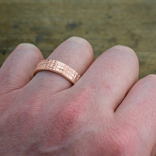 Detailed texture and polish on the 14k rose gold men's wedding band