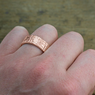 Detailed view of 14k Rose Gold Mens Wedding Band showing off textured design and high polish