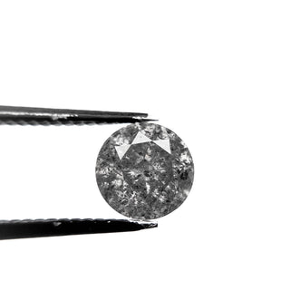 1.43 Carat Salt and Pepper Brilliant Cut Round Diamond held by tweezers, showcasing unique speckled patterns and handcrafted eco-friendly conflict free design.