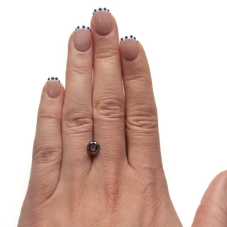 Hand wearing a 1.94 Carat Salt and Pepper Double Cut Oval Diamond ring, featuring an eco-friendly, unique salt and pepper diamond with a handcrafted design.