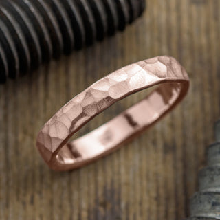 4mm 14k Rose Gold Mens Wedding Band with hammered matte texture in unique perspective view