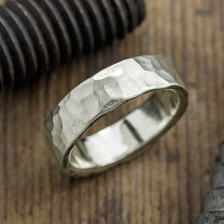 Close-up image of a 14k white gold men's wedding band, showcasing the intricate 6mm hammered matte finish