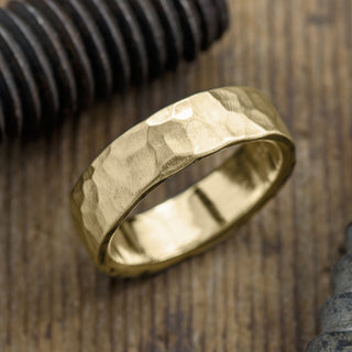 Close-up view of a 6mm 14k Yellow Gold Men's Wedding Band, highlighting the hammered matte texture