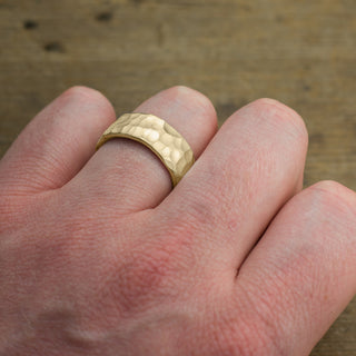 Close-up view of the hammered detail on a 14k Yellow Gold Men's Wedding Band with matte finish