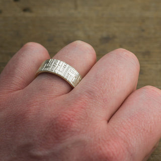 Close-up view of men's 14k white gold wedding ring with 8mm width, showcasing textured detailing and matte finish