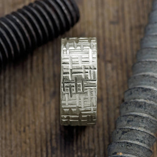 Close-up view of a 10mm 14k white gold men's wedding band featuring a unique textured matte design