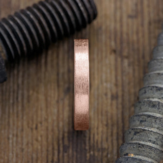 Close-up view of a 4mm 14k Rose Gold Men's Wedding Band with Matte Finish