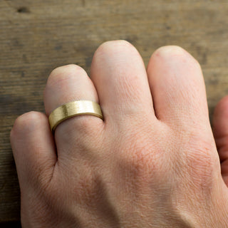 Close up shot of the 6mm 14k Yellow Gold Men's Wedding Band with detailed matte finish showing the fine craftsmanship