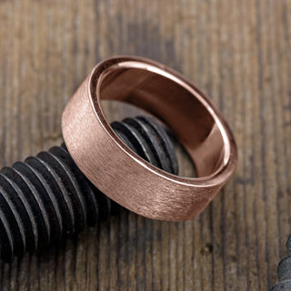 14K Rose Gold 8mm Wedding Band for Men, displayed side-on to show thickness and curved edges