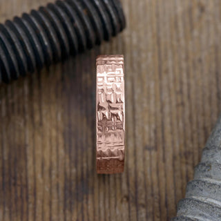 Close up of the textured polished design on the 14k rose gold men's wedding band