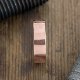 Close-up view of 6mm 14k Rose Gold Mens Wedding Band, detailing its polished surface