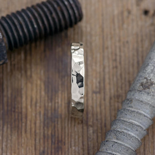 Close-up of the 4mm 14k White Gold Mens Wedding Ring showing its hammered polished texture