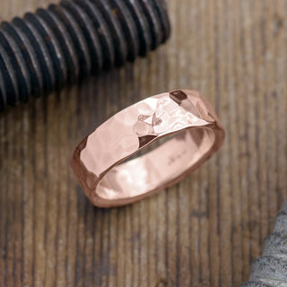 6mm 14k Rose Gold Men's Wedding Band displayed against a white background, showcasing its hammered and polished texture