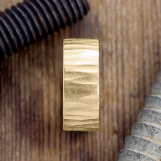 Angled view of the 10mm 14k Yellow Gold Mens Wedding Band with wood grain matte detailing