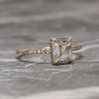 Angled view of the 1.55 carat emerald shaped clear diamond engagement ring featuring a rose gold Jules setting